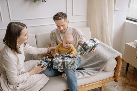 Moment de partage en famille lors de l’ouverture d’un cadeau de naissance : un sac à langer pratique et élégant