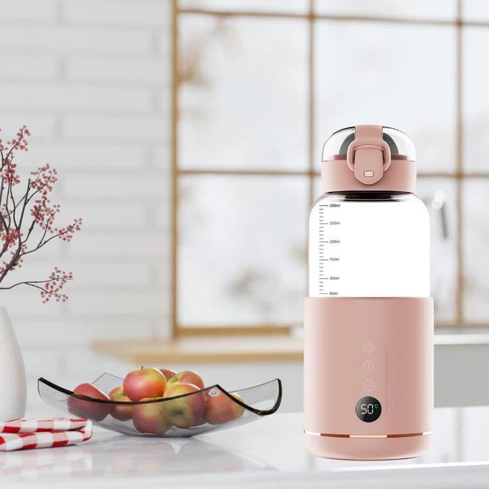 Chauffe-biberon nomade rose posé sur une table de cuisine prêt à chauffer le lait