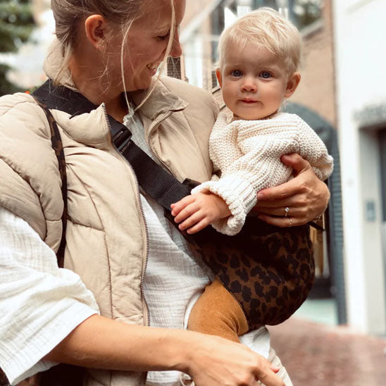 Écharpe de portage motif léopard bébé porté en position latérale par la maman