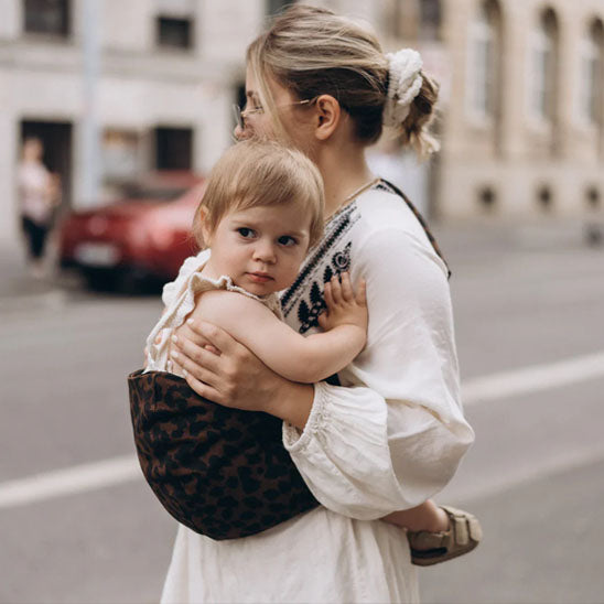 Bébé porté face à la maman avec une écharpe de portage confortable et sécurisée