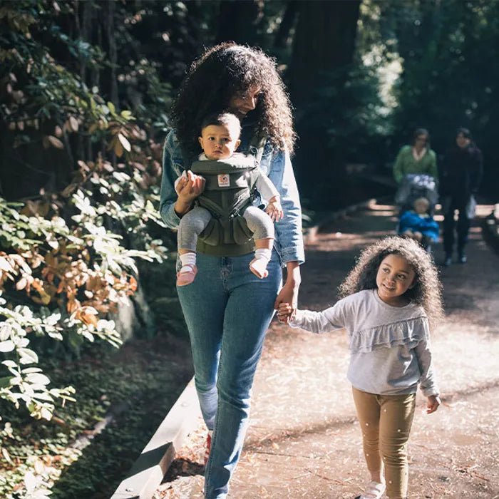 Maman et sa petite fille en balade, bébé bien attaché dans un porte bebe confortable et sécurisé