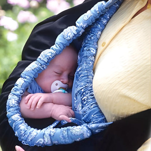 Bébé profondément endormi dans une écharpe de portage confortable