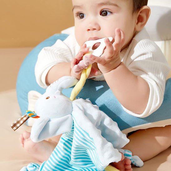 Bebe jouant avec un doudou bebe elephant bleu doux et rassurant