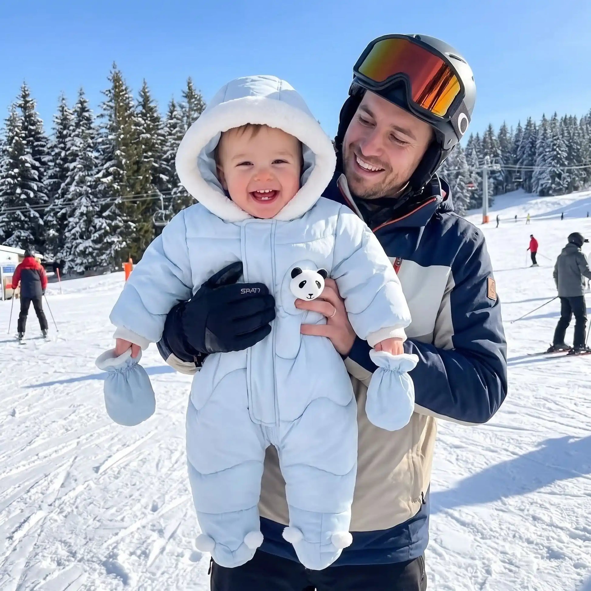 Bébé portant une combi pilote bébé motif petit panda lors d'une sortie hivernale à la montagne, idéale pour rester au chaud pendant l'hiver