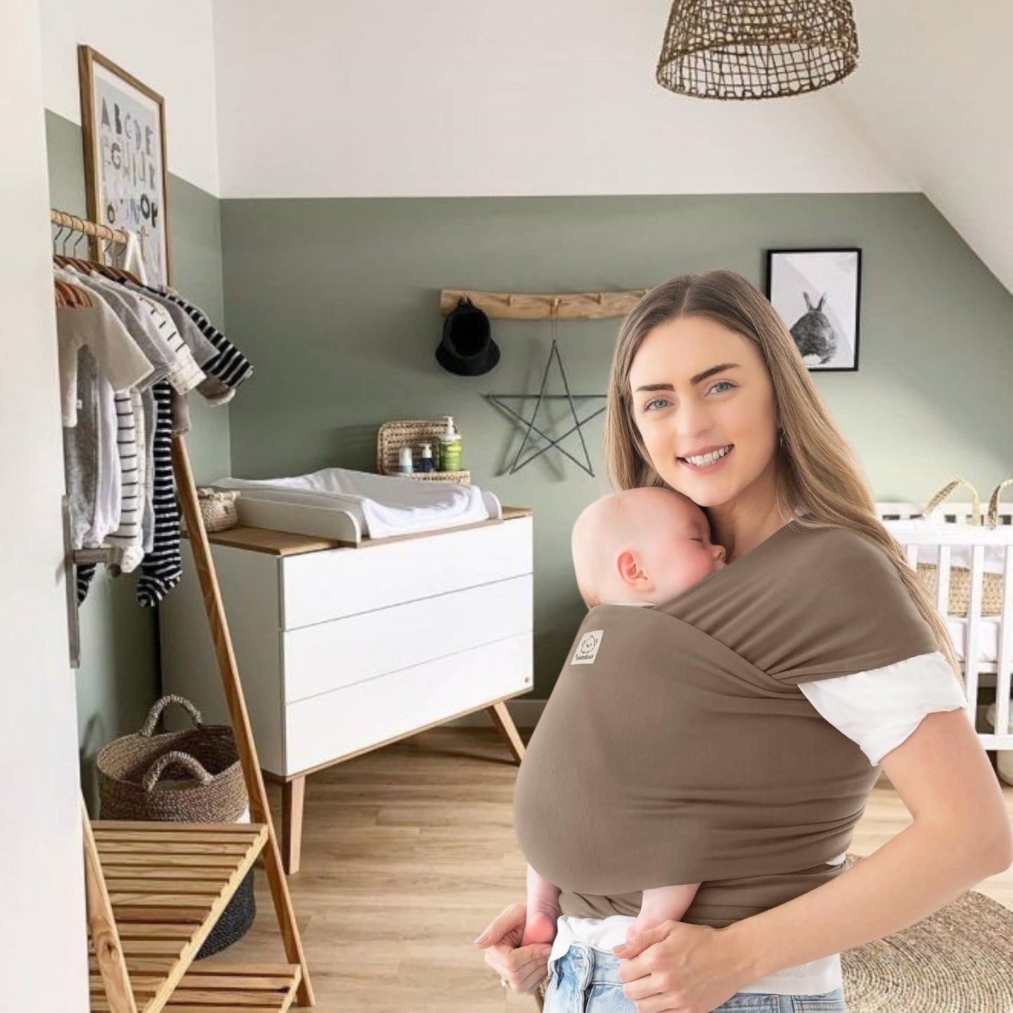 Maman portant son bébé dans une écharpe de portage bébé marron confortable à la maison, moment de tendresse et de sécurité