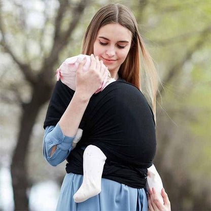 Écharpe de portage noire avec bébé confortablement installé sur l’épaule de maman, proximité et maintien optimal