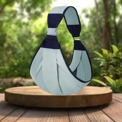 Echarpe de portage bébé de couleur verte, exposée sur une table en bois dans le jardin, confort et praticité