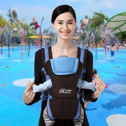 Maman portant bébé avec un porte bébé physiologique bleu et noir pratique lors sortie au parc aquatique