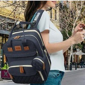 Maman au look tendance avec un sac à dos à langer porte sur l’épaule