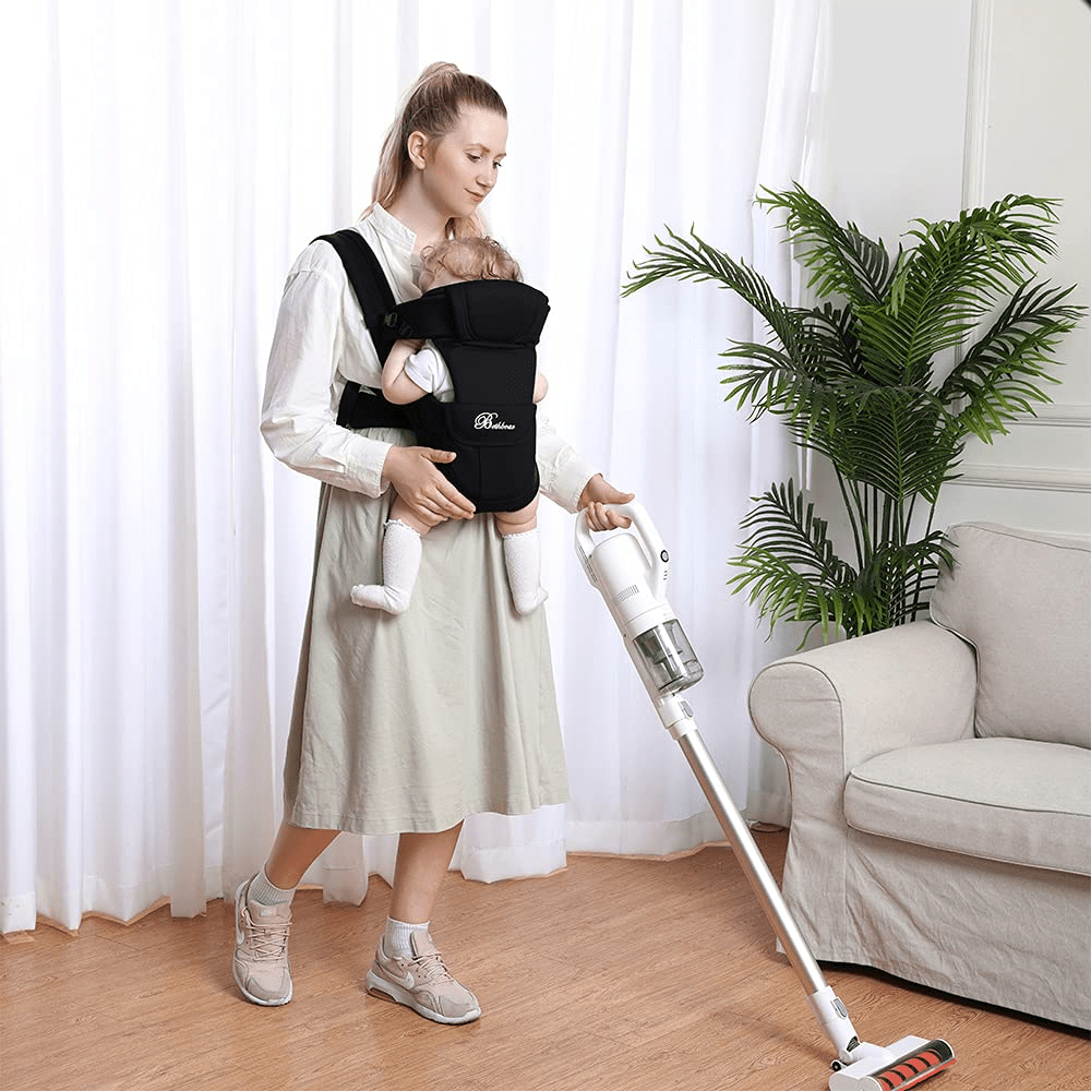 Maman travaillant et portant son bébé en porte bébé physiologique confortable