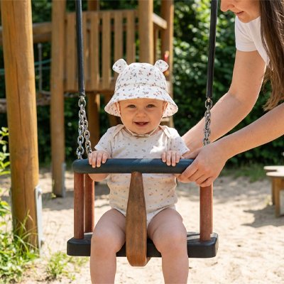 Petite princesse portant bob bebe motif fleur jouant a l'aire de jeu avec chapeau soleil