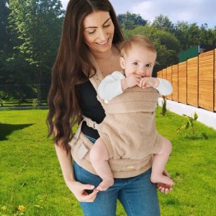 Porte bébé physiologique avec bébé en portage avant face au monde, profitant de la vue du jardin