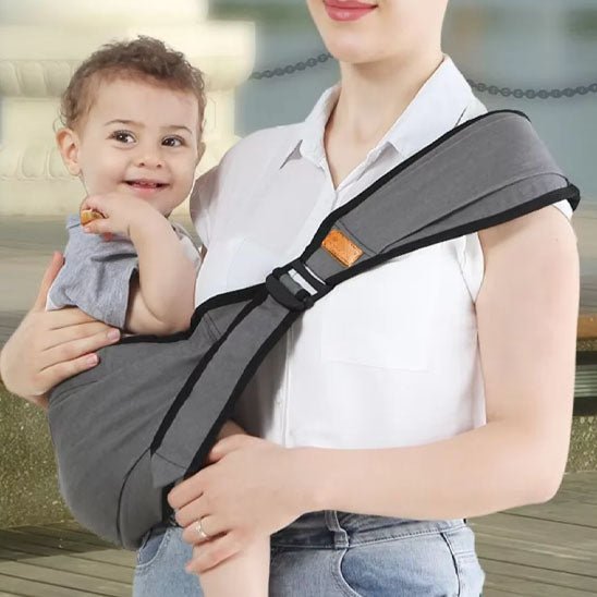 Porte bebe gris en portage latéral, très pratique et confortable pour bébé et parent