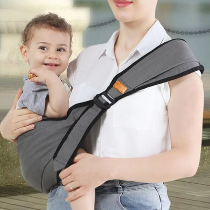 Porte bebe gris en portage latéral, très pratique et confortable pour bébé et parent