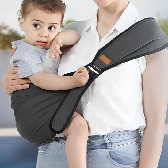 Porte bebe noir en portage latéral, très pratique et confortable pour bébé et parent