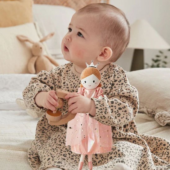 Petite princesse jouant avec son doudou bébé fille portant une robe et une couronne, peluche douce