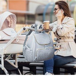 Sac a dos a langer Tinytote accroche a une poussette, femme au telephone