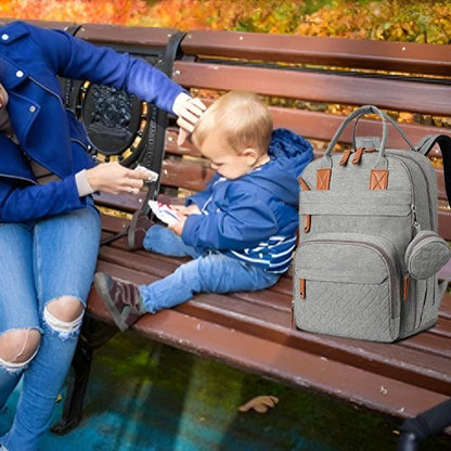 Maman essuyant son bébé sur un banc avec un sac a langer pratique et stylé pour sorties quotidiennes