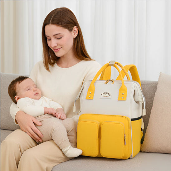 Maman avec son bébé au parc portant un sac a langer jaune pratique et tendance