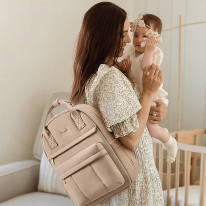 Maman portant son bébé et un sac à langer sac à dos beige élégant sur le dos dans un intérieur chaleureux