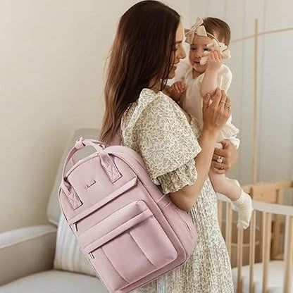 Maman portant son bébé et un sac à langer sac à dos rose élégant sur le dos dans un intérieur chaleureux