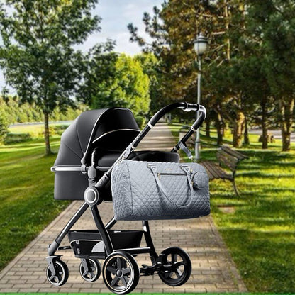 Sac pour bébé gris accroché facilement à une poussette pendant une sortie avec bébé
