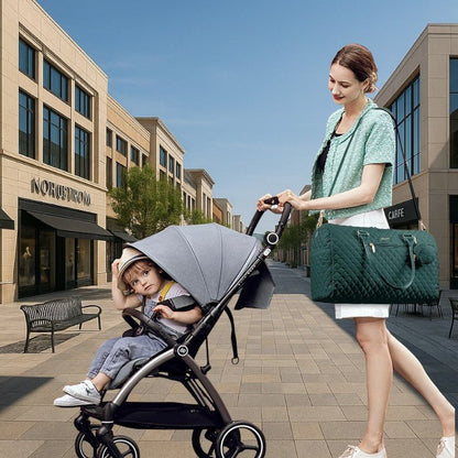 Maman en balade poussant poussette et portant un sac pour bébé sur l’épaule