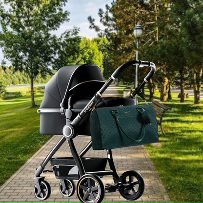 Sac pour bébé vert accroché facilement à une poussette pendant une sortie avec bébé